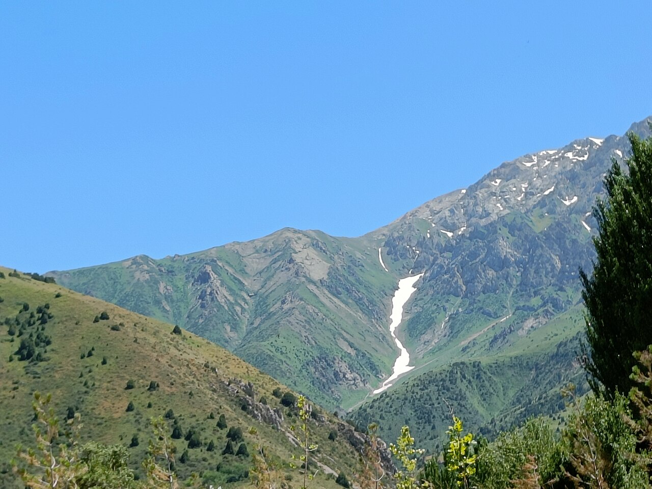 Juniper-dotted slopes and snow-streaked ridges of the Talas Alatau in Aksu-Zhabagly