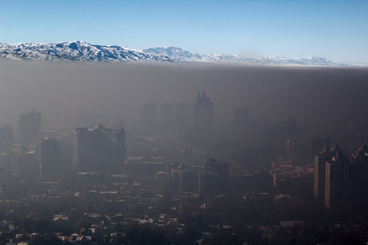 Thick winter smog trapped over Almaty beneath the snow-capped Tian Shan