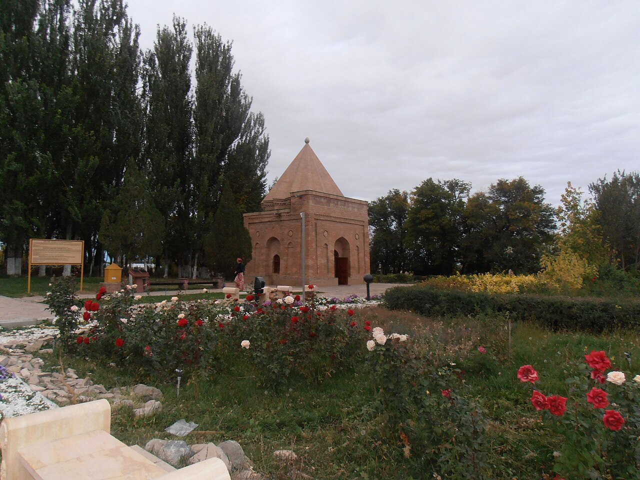 The plain brick Babaji Khatun mausoleum with its sixteen-faceted conical dome in a rose garden near Taraz