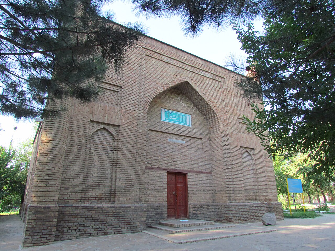 The brick Karakhan mausoleum in central Taraz with its pointed arch portal and turquoise inscription tile