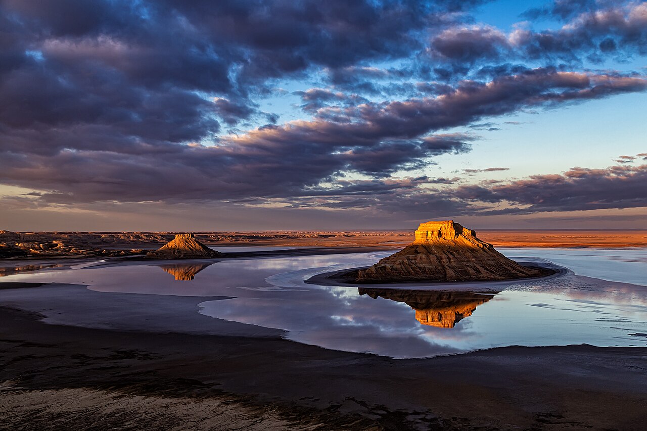 The Three Brothers outliers reflected in the flooded floor of the Karynzharyk depression at sunset