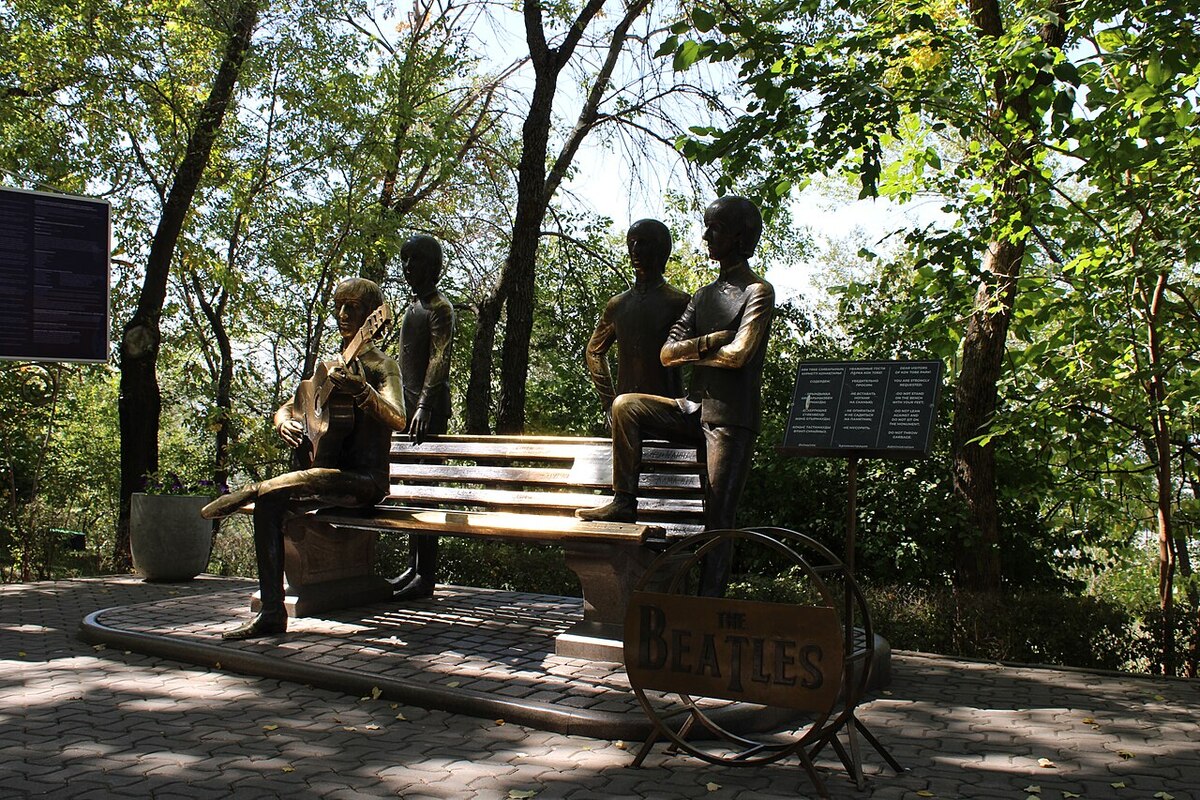 The bronze Beatles monument on Kok Tobe hill in Almaty, John Lennon seated on a bench with the other three standing